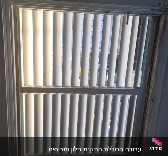 חלון עם תריסי אלומיניום פתוחים למחצה